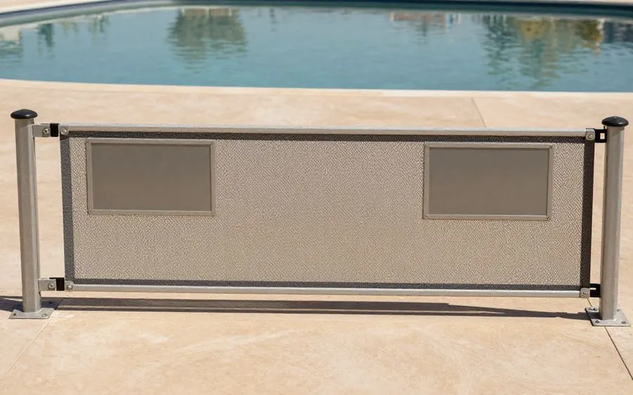 A tensioned mesh pool barrier with a self-closing gate section across a pool deck